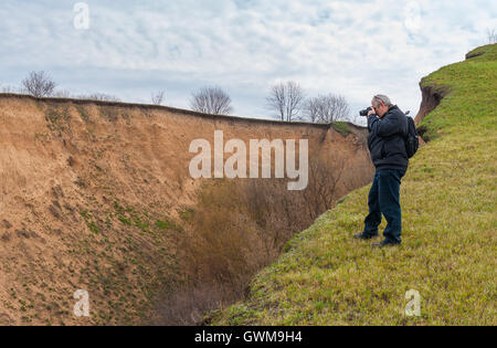 Reife Fotograf unter Foto stehen am Rande der Schlucht im Frühling Stockfoto