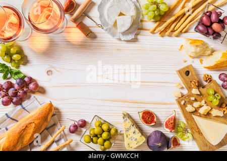 Verschiedene Arten von Käse, Wein, Baguette und Früchte auf weiß Stockfoto