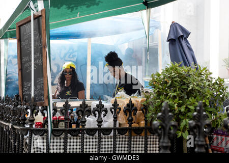 Einheimische Küche und Verkauf karibisches Essen außerhalb ihrer Häuser während der Notting Hill Carnival Stockfoto