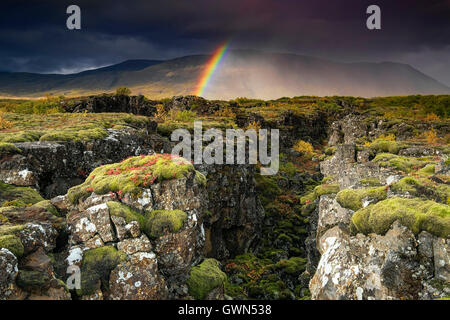 Regenbogen und Regensturm über der tektonischen Plattenspalte, unterstützt vom Armannsfell Mountain, Thingvellir National Park, Südwestisland