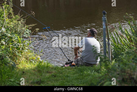 Fischer am Ufer des Flusses einsamer Angeln mit Rute Sommertag. Stockfoto