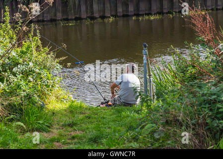 Fischer am Ufer des Flusses einsamer Angeln mit Rute Sommertag. Stockfoto