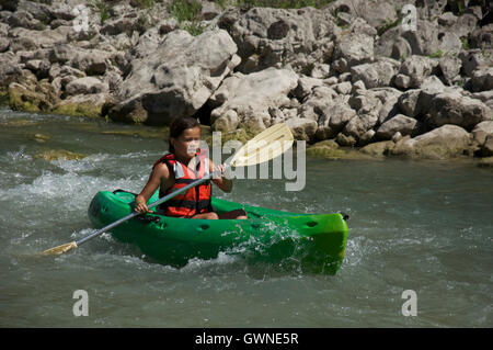 Tourismus, Wassersport. Ein junges Mädchen paddelt ihr Kanu hinunter die turbulenten schnellen fließenden Gewässern des Flusses Drôme. In der Nähe von Saillans, La Drôme in Frankreich. Stockfoto