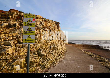 Warnzeichen neben Kreidefelsen auf Promenade, Seaford, East Sussex, England Stockfoto