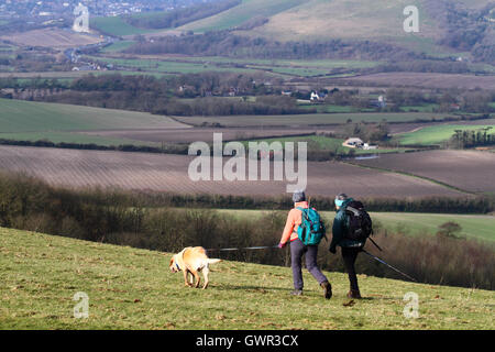 Frauen gehen mit Hund in der Nähe von Firle Leuchtfeuer im Winter, South Downs National Park, East Sussex, England, UK Stockfoto