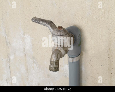 Wasserhahn an Betonwand Stockfoto