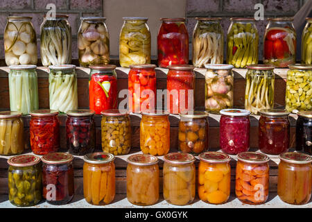 Eingelegtes Gemüse und Obst in Gläsern. Stockfoto