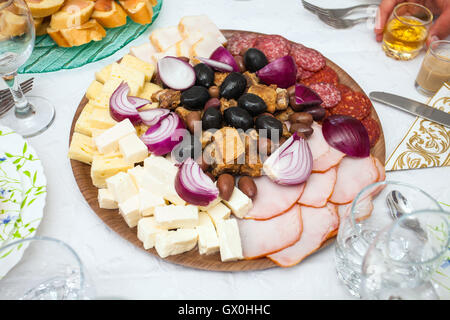 Cocktail Essen Vorspeise mit Schinken, Salami, rote Zwiebeln, Schweinekoteletts und eine Vielzahl von Oliven und Käse Stockfoto