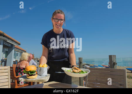 Kellnerin serviert Essen zu The Strand-Deck. Eastbourne. Sussex. England. UK Stockfoto