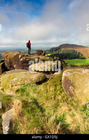 Eine Walker Stand auf Ramshaw Felsen in Richtung Henne Wolke an der Hinterwellen, Peak District National Park, Staffordshire. Stockfoto