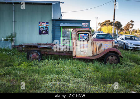 Eine rostige alte LKW, hohen Gras neben einem gebrauchten Auto Hof Stockfoto