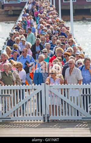 Menschenmassen stehen am Yarmouth Pier Schlange und warten auf den Paddeldampfer Waverley, der im September für eine Reise um die Isle of Wight, Hampshire UK, eintrifft Stockfoto