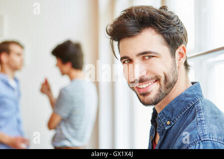 Junger Mann als Schüler glücklich lächelnd in seinem Start-up-Unternehmen Stockfoto