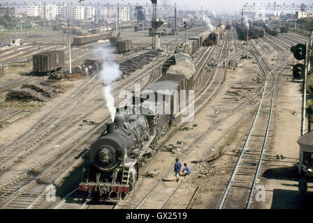 Ein China Railway JF Klasse Mikado zieht einen schwere Rechen der Wagen durch Sankong Hof vor ihnen Buckel geschoben, August 1985. Stockfoto