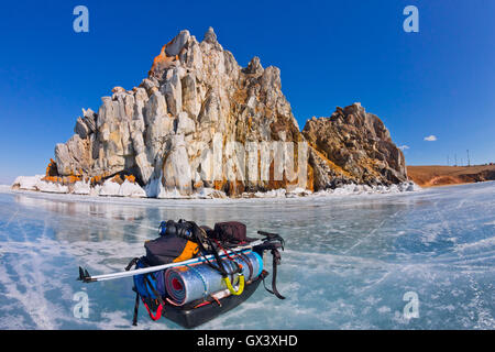Eis-Schlitten, Ski-Stöcke und Rucksack vor Schamanen Rock am Baikal-See Stockfoto