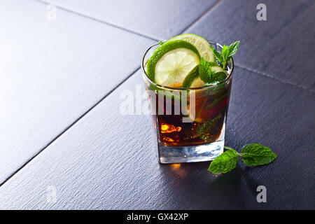 Trinken Sie mit Cola, Limetten, Eis und Pfefferminz-Blätter Stockfoto