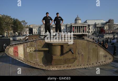 Mitglieder des Royal Tank Regiment stehen auf einem Replikat ersten Weltkrieg Mark IV Panzer auf dem Londoner Trafalgar Square anlässlich der Hundertjahrfeier der eines gepanzerten Fahrzeugs erstmals Einsatz in der Schlacht an der Somme. Stockfoto