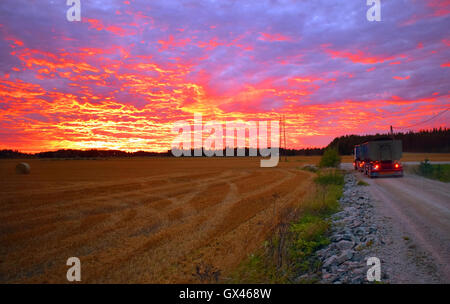 LKW und Feld unter schönen Sonnenuntergang Himmel in Südfinnland. Stockfoto