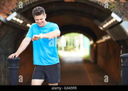 Man Looking At Aktivitätsprotokoll während des Trainings im städtischen Umfeld Stockfoto