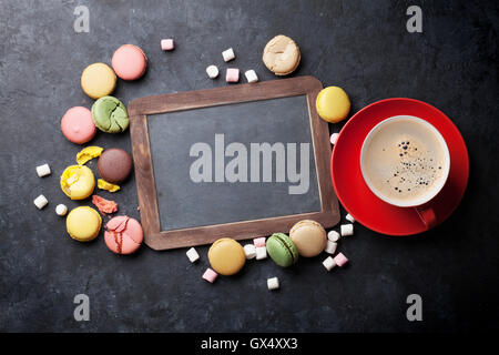 Bunte Makronen, Kaffee und Tafel. Süßen Macarons am Steintisch. Draufsicht mit textfreiraum für Ihren text Stockfoto