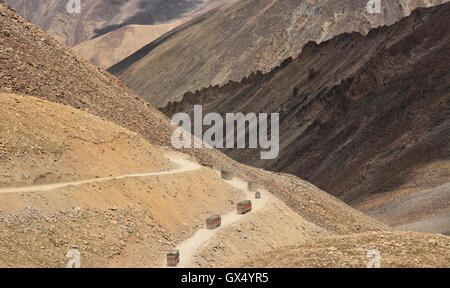 LKW fahren auf einer Bergstraße durch felsigen und kargen Landschaft in Ladakh im Bundesstaat Jammu & Kaschmir, Indien. Stockfoto