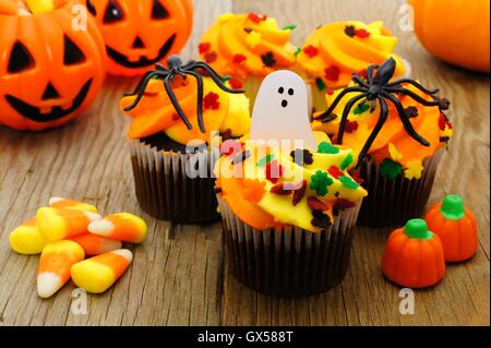 Halloween Cupcakes und Süßigkeiten auf rustikalen Holztisch Stockfoto