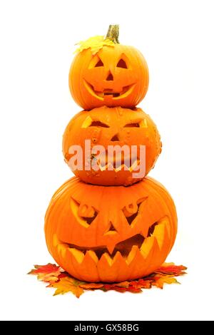 Gruppe von drei gestapelte Halloween Jack o Laternen mit Herbst Blätter Stockfoto