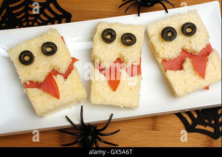 Lustige Halloween-Monster-Sandwiches auf einem Teller mit Holz Hintergrund Stockfoto