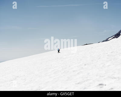 Ein einsamer Wanderer auf dem Schnee bedeckt Wanderweg zum Gipfel des Mt. Rainier Stockfoto