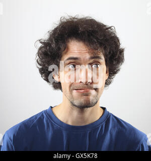 Überrascht, hübscher junger Mann im blauen Hemd. Stockfoto