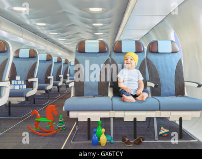 kleiner Junge in der Flugzeugkabine. Fotokonzept Kombination. Stockfoto