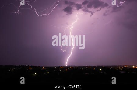 Ein tropisches Gewitter über einer Landstadt mit Blitzschlag Stockfoto