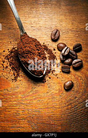 Frisch gemahlener Kaffee im Löffel auf hölzernen Hintergrund Stockfoto