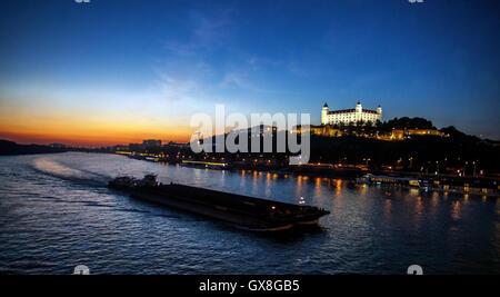 Bratislava Burg Donau Slowakei, Boot auf der Donau in Sonnenuntergang Schifffahrt Handel Europa Stadt Fluss Stockfoto