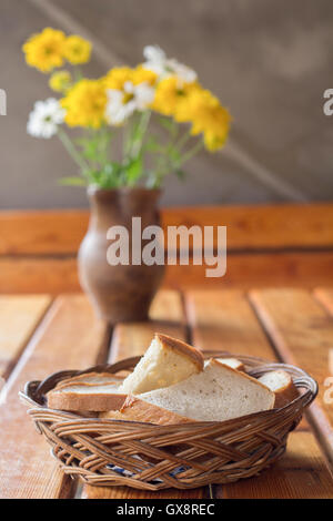 Weidenkorb mit Brot und Blumen Stockfoto