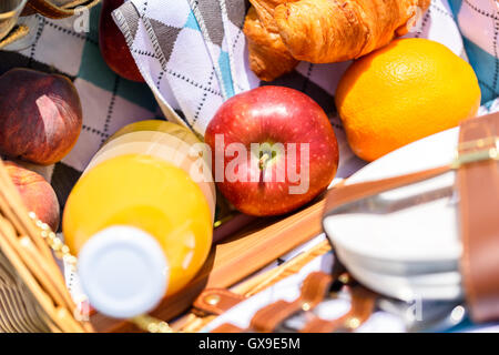 Saftflasche, Pfirsich, Apfel, Orange und Croissant In Essen-Picknick-Korb Stockfoto