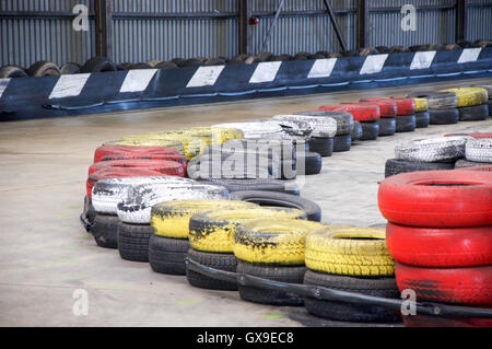 Indoor Autorennen Track Detail von den übereinander getragen und bunte Gummireifen Grenze Sicherheit Stoßfänger mit konkrete Spur. Stockfoto