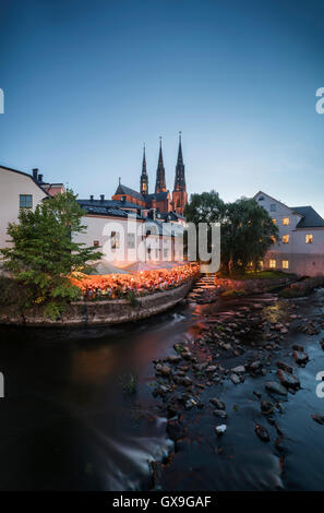 Nacht in der alten Mühle am Kvarnfallet im Fluss Fyris mit der Kathedrale (Domkyrkan) im Hintergrund, Uppsala, Schweden Stockfoto