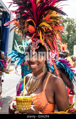 Lächelnd einheimischer hält eine wulstige Drink Cup in Notting Hill Carnival Stockfoto