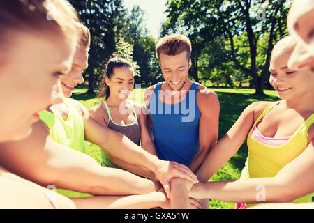 Gruppe der happy Friends mit Händen an der Spitze im freien Stockfoto