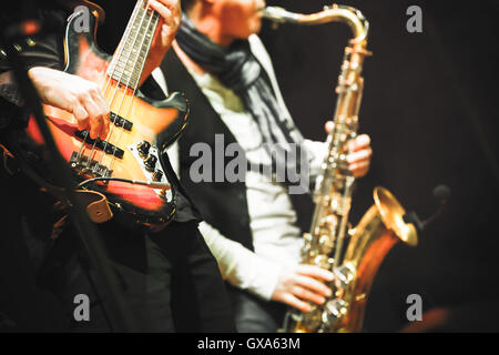 Musikalische Untermalung, Gitarrist und Saxophonist auf eine Bühne mit bunten Beleuchtung, Foto mit Tiefenschärfe und Retro Stockfoto