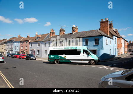 Devizes Wiltshire UK - alte Reihenhäuser in dieser englischen historischen Marktstadt und Wiltshire Grafschaftsrat finanzierten bus Stockfoto