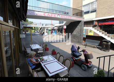 Gesamtansicht der Behinderung Roller geparkt vor einem Café im Stadtzentrum von Harlow Essex. Stockfoto