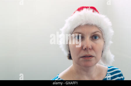 Überrascht Frau mit Weihnachten Weihnachtsmann Hut in fröhlichen Urlaubsstimmung Vorbereitung auf Weihnachten oder Silvester. Stockfoto