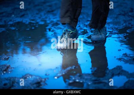 Füße von weiblichen Wanderer verstärkt in schlammigen Pfütze Stockfoto