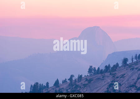 Half Dome bei Sonnenuntergang, der Berg teilweise Obscurred durch Rauch aus 2014 Dog Rock ein Lauffeuer, Yosemite, Kalifornien, USA. Stockfoto