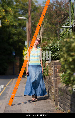 Fußgängerzone / Lady / junge Frau / Menschen / Person laufen unter einer Leiter und Pech in Twickenham, Greater London zu riskieren. UK Stockfoto