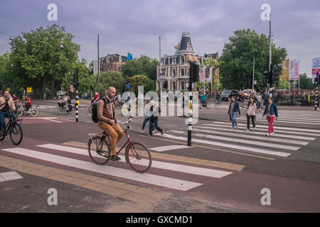 Radfahrer und Fußgänger an einer belebten Straßenkreuzung in der Nähe von Bezirk Museum, Amsterdam, Niederlande. Stockfoto