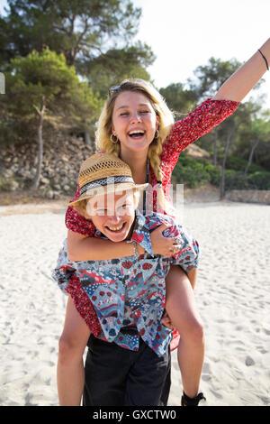 Mann am Strand geben lächelnde Frau Huckepack, Mallorca, Spanien Stockfoto