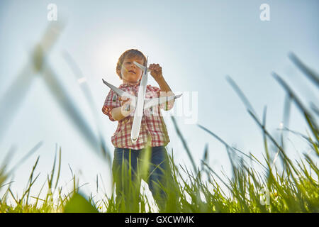 Niedrigen Winkel Blick auf junge Gras Überprüfung Spielzeug Flugzeug Heck Stand Stockfoto